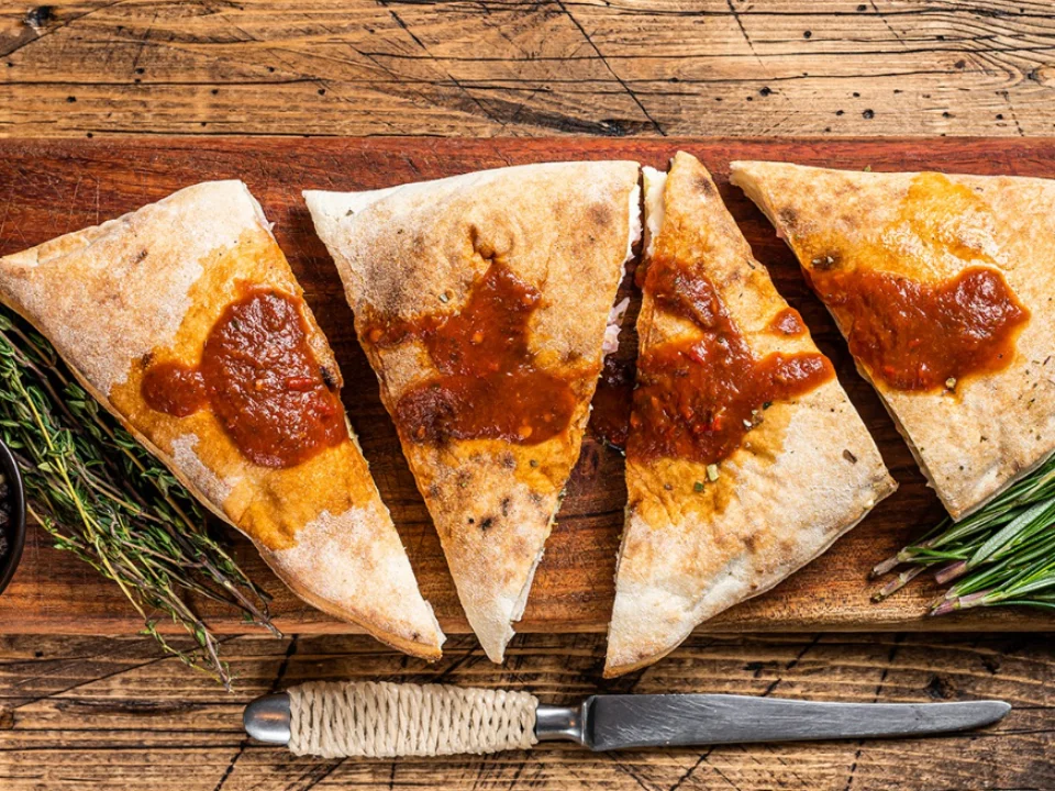 Calzone - A golden-baked pocket of dough stuffed with ricotta, mozzarella, and your choice of fillings — crispy outside, cheesy and delicious inside.